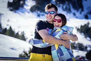 Prints of Couple, male and female, of skiers hugging and enjoying their winter holidays with winter background. El Tarter, Grandvalira, Andorra Andorra Prints: Winter Holiday Print: El Tarter, Andorra