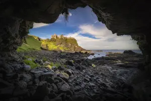 Prints of Dunluce Castle seen from a small cave on a shoreline, nested on the edge of cliff, part of Wild Atlantic Way, Bushmills, Northern Ireland Castle Prints: Dunluce Castle Print - Bushmills, Northern Ireland
