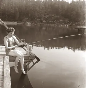 Retro Swimwear Fashion Prints: Fishing in the 1950s. A young woman wearing a swimsuit is fishing