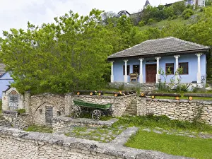 Prints of Traditional blue house with stone wall and green wagon in a rural area aerial view, traditional farmhouse, ethnographic museum, Butuceni, Old Orhei, Orheiul Vechi, archaeological site Moldova Prints: Traditional Blue House Print, Orheiul Vechi, Moldova
