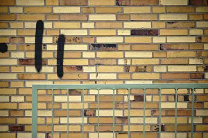 Old Building Architecture Prints: A wall made of old clinker bricks with an angular railing in front of it