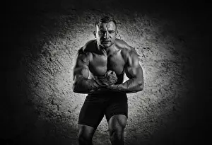 Young Man Posing Prints: The weightlifter is posing in front of the camera
