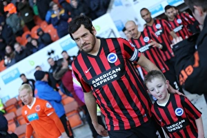 <b class=qtipBold><figcaption>Blackpool v Brighton and Hove Albion</figcaption></b><br>Gordon Greer, Brighton skipper with the mascot during the Sky Bet Championship match between Blackpool and Brighton and Hove Albion at Bloomfield Road, Blackpool, England on 31st January 2015.<br><em>© A©Brighton and Hove Albion</em> Blackpool v Brighton and Hove Albion
